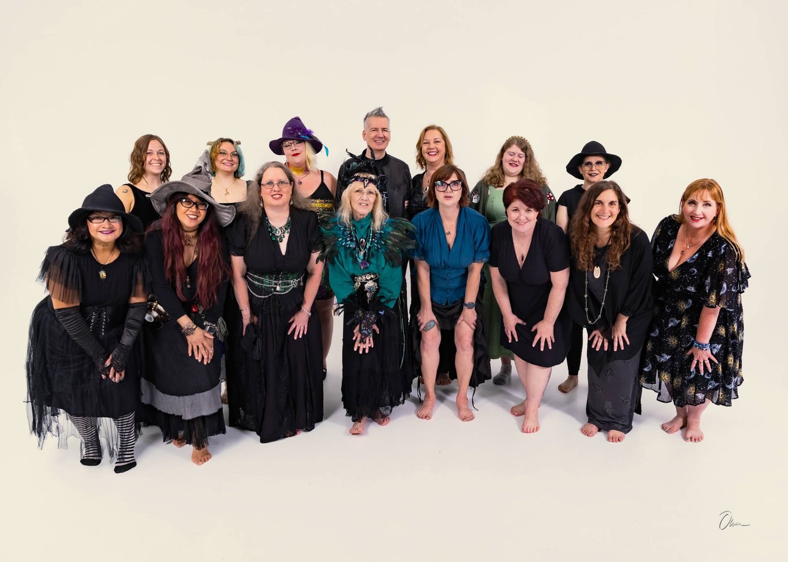 Members of the Forest City Dance Circle in dark seasonal costume and pointed hats, leaning in together and smiling for a group portrait in Rockford, Illinois.